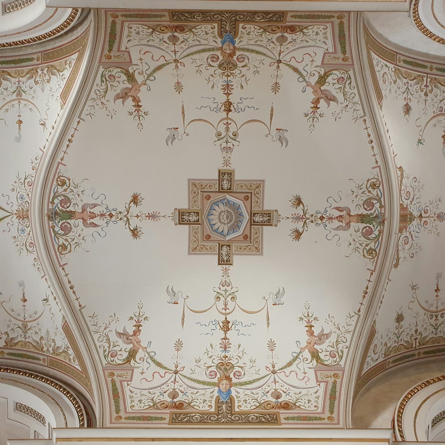 Soffitto ornato dipinto con ghirlande floreali e putti.