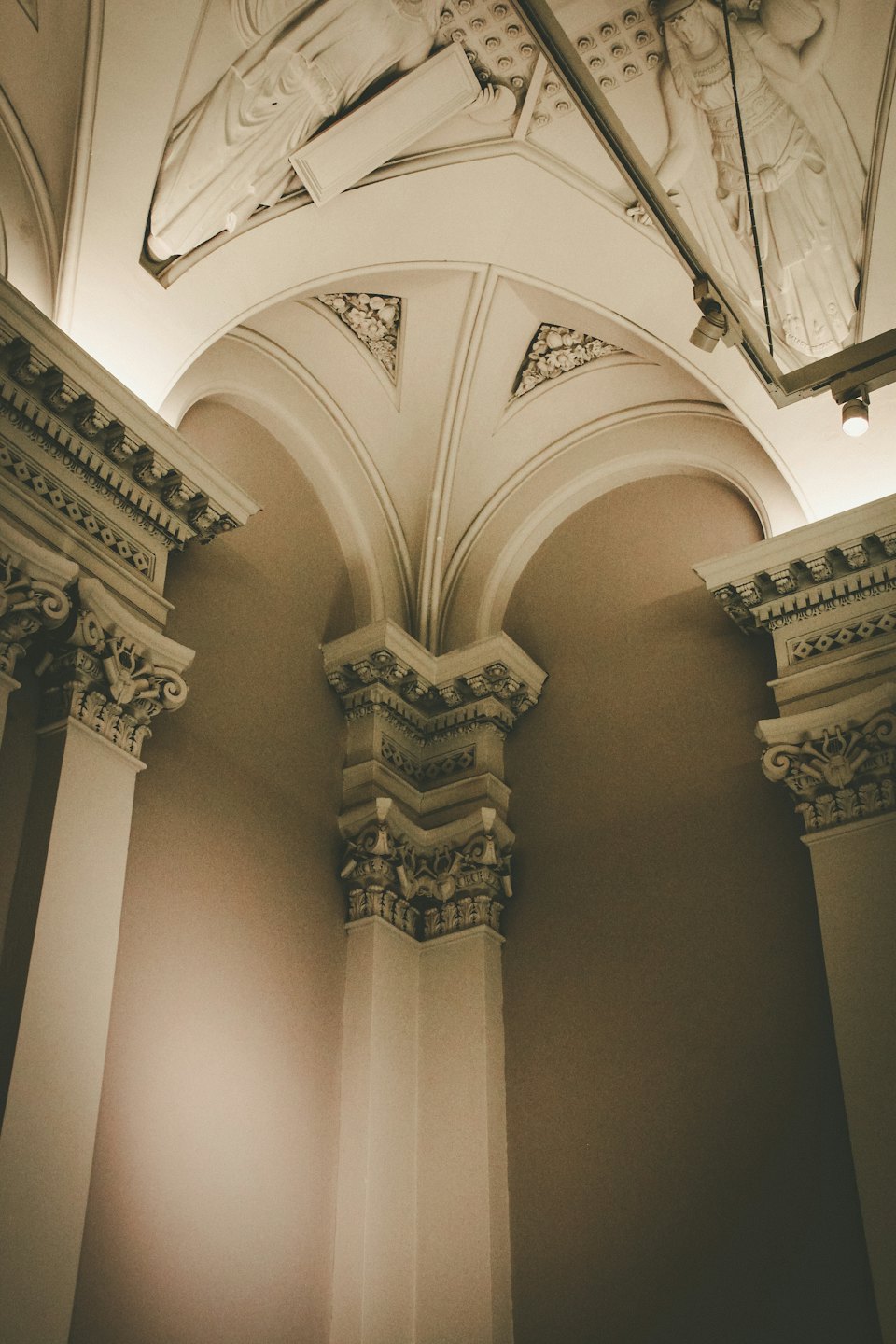 Dettagli di colonne e archi ornati con stucchi e soffitti a volta.